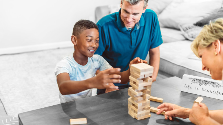 Enfant qui joue avec des jouets en bois avec ses parents